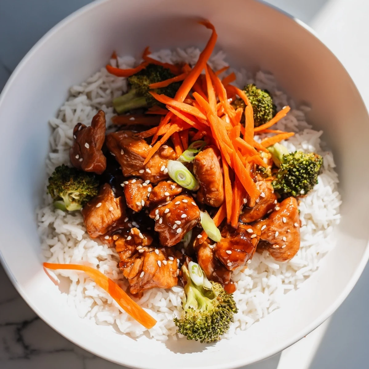 Golden chicken teriyaki bowls with glistening sauce, sesame seeds, and fresh scallions served over fluffy rice.