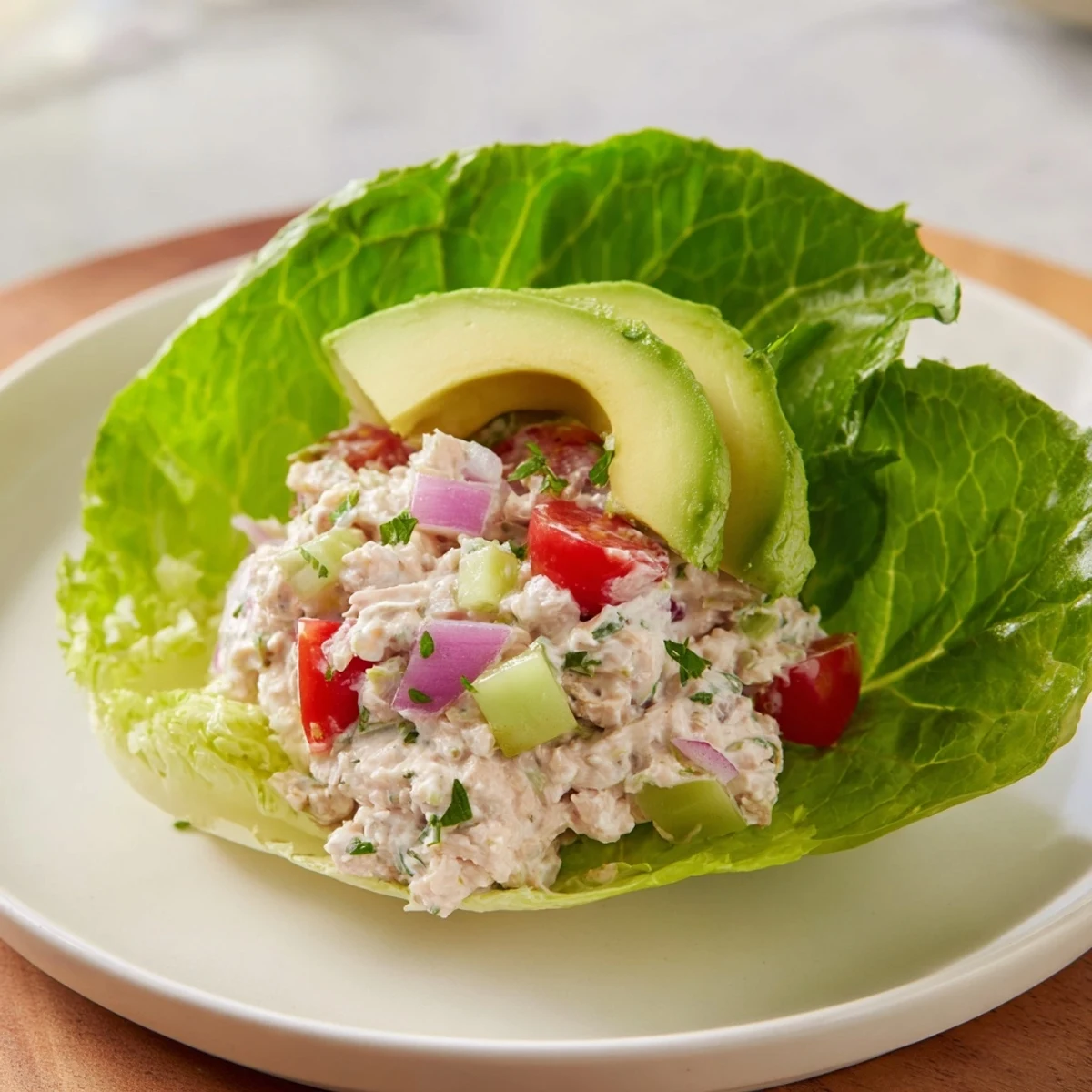 Fresh, crunchy tuna salad lettuce wraps, filled with creamy avocado and diced tomato, ready to eat.