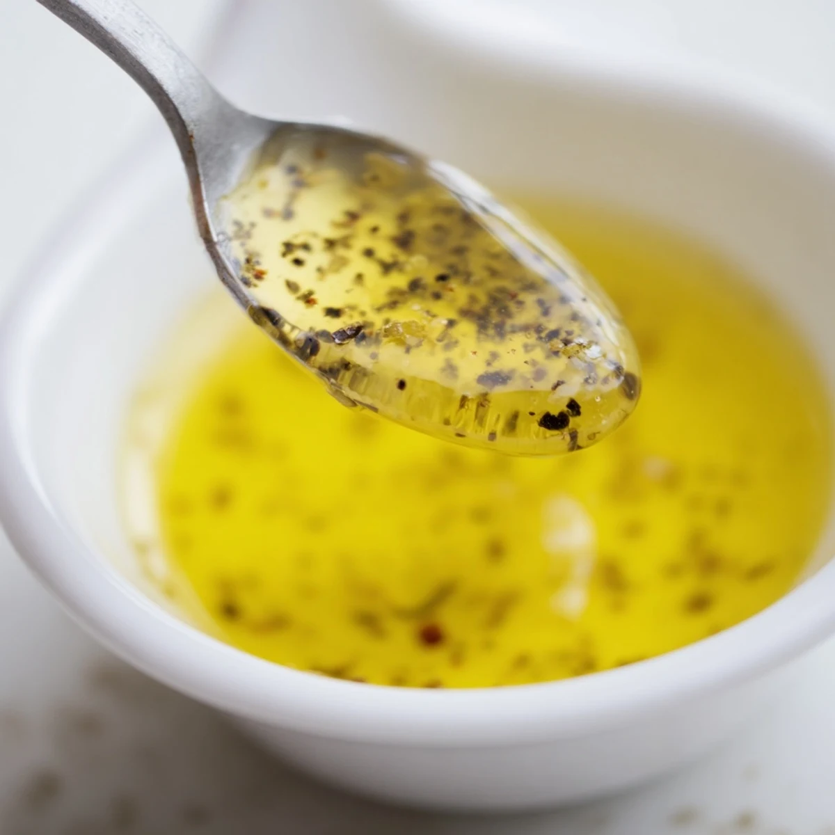 This Simple Honey Vinaigrette Salad Dressing is a bright, clear view of ingredients whisking together.