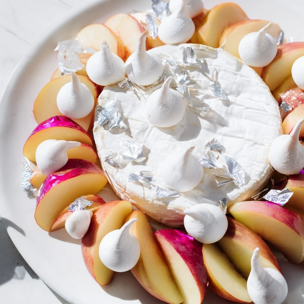The Pearly Gates cheese board features creamy brie, sweet peaches, delicate meringue, and shimmering edible silver.