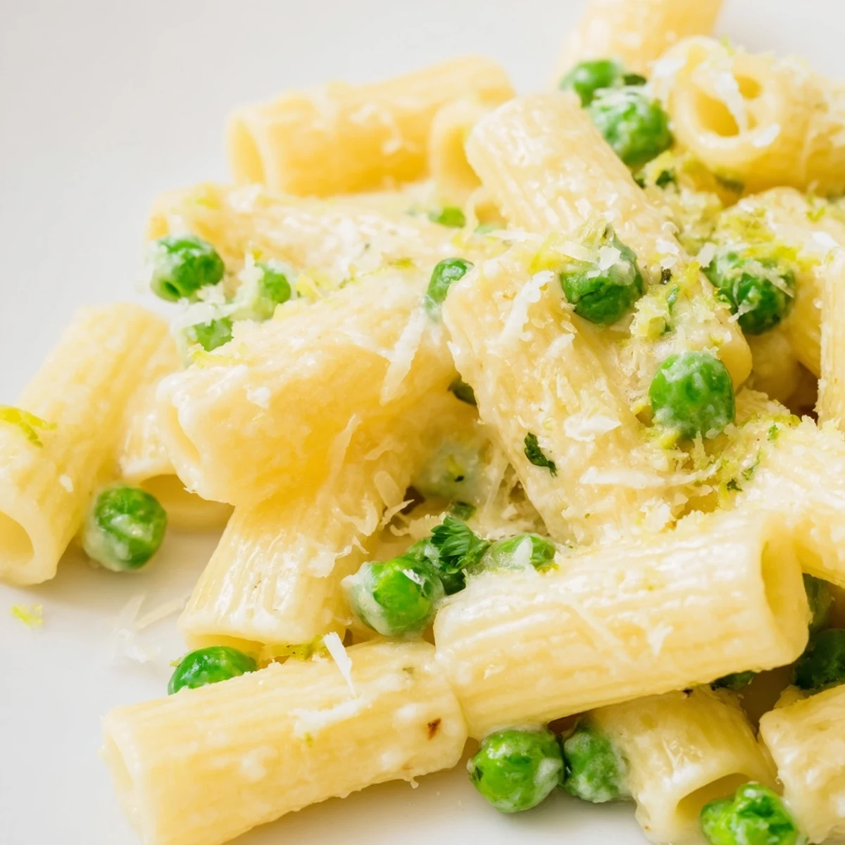 Hearty vegetarian rigatoni pasta with sweet peas and tangy lemon ricotta sauce, perfect for a quick dinner.