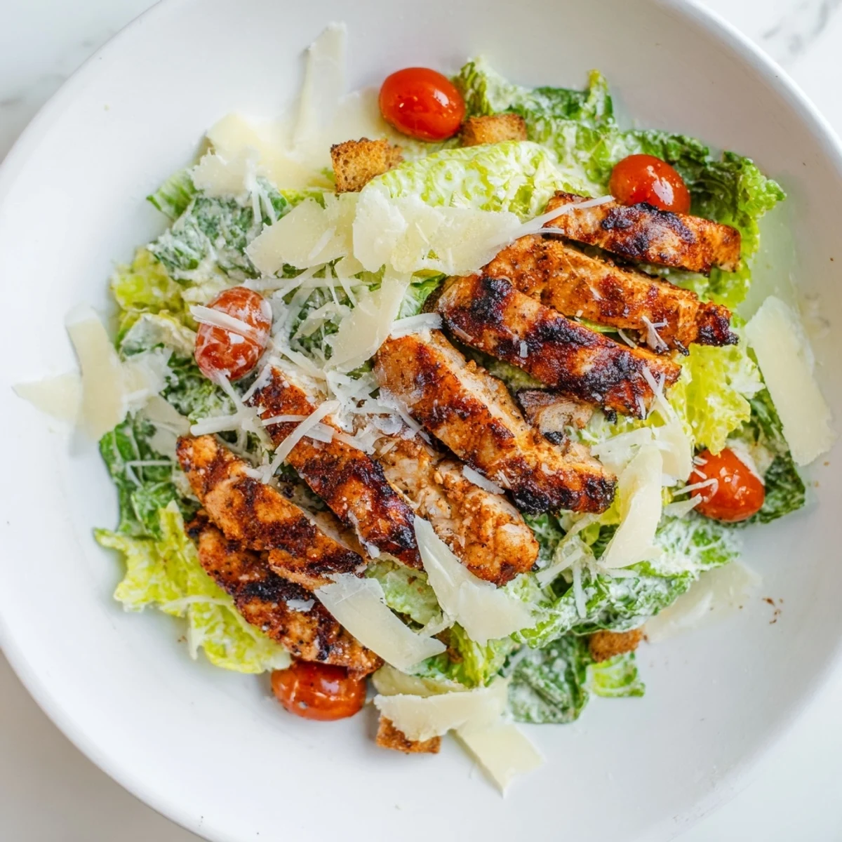 In this Yogurt Caesar Grilled Chicken Salad, shaved Parmesan and a tangy homemade yogurt Caesar dressing add savory flavor.