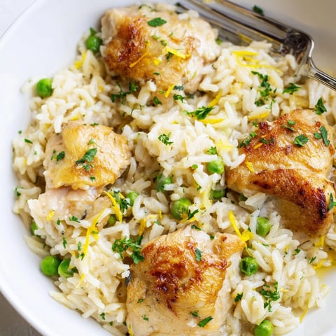 Creamy lemon chicken and rice served in one pot, garnished with fresh parsley for a cozy dinner.