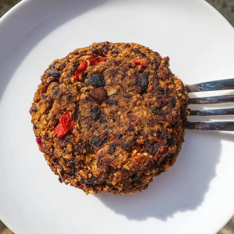 Delicious, spiced black bean burgers sizzling in a pan, promising a flavorful, vegetarian meal.