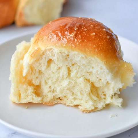 Freshly baked golden dinner rolls are pictured, perfect for sharing and a welcome addition to any table.