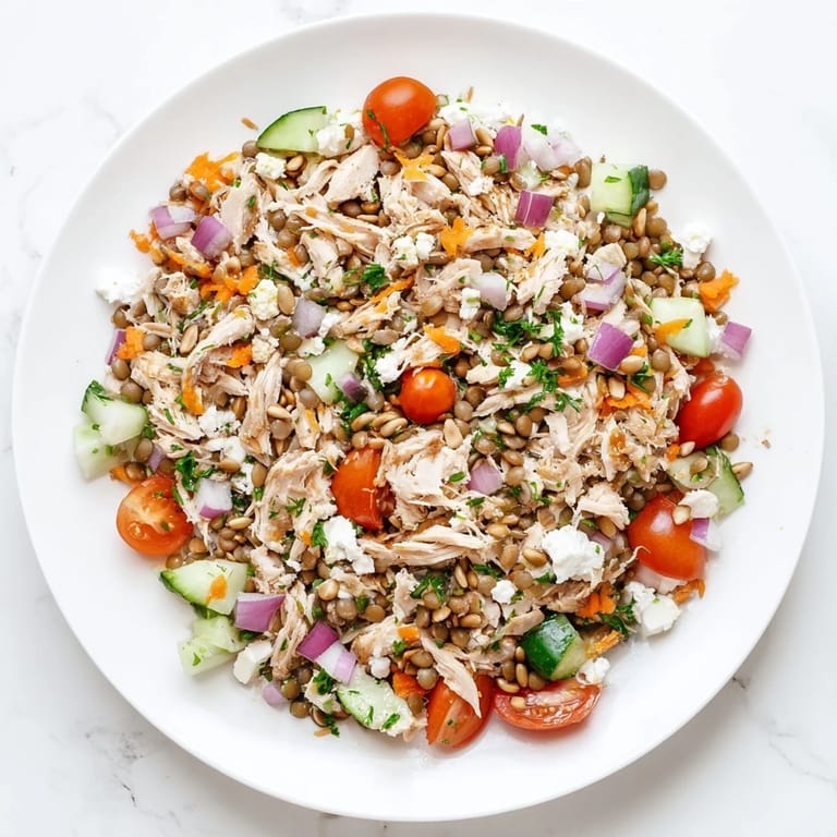 Hearty Chicken and Lentil Recession Salad, picture ready to eat, with a creamy vinaigrette dressing drizzled over it.