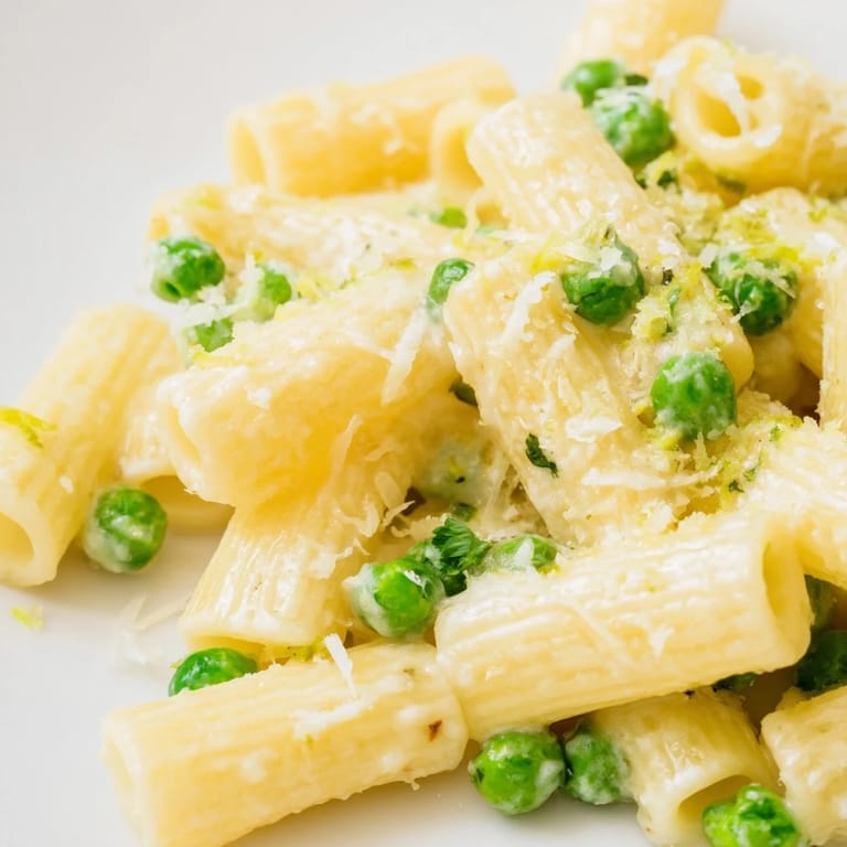Hearty vegetarian rigatoni pasta with sweet peas and tangy lemon ricotta sauce, perfect for a quick dinner.