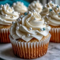 Soft vanilla cupcakes with pearl fondant toppers for Cancer birthdays.